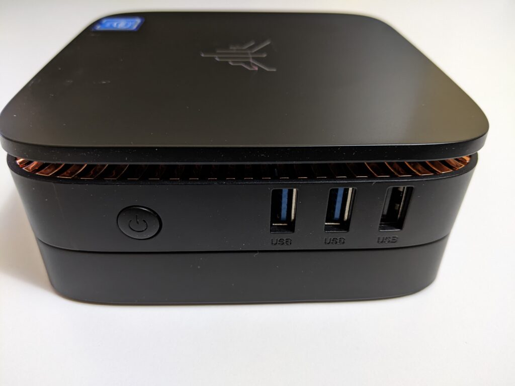 Image of the side of the Kamrui AK1 Pro Mini PC.  Image features power button, 2x USB 3.0 ports and a USB 2.0 port