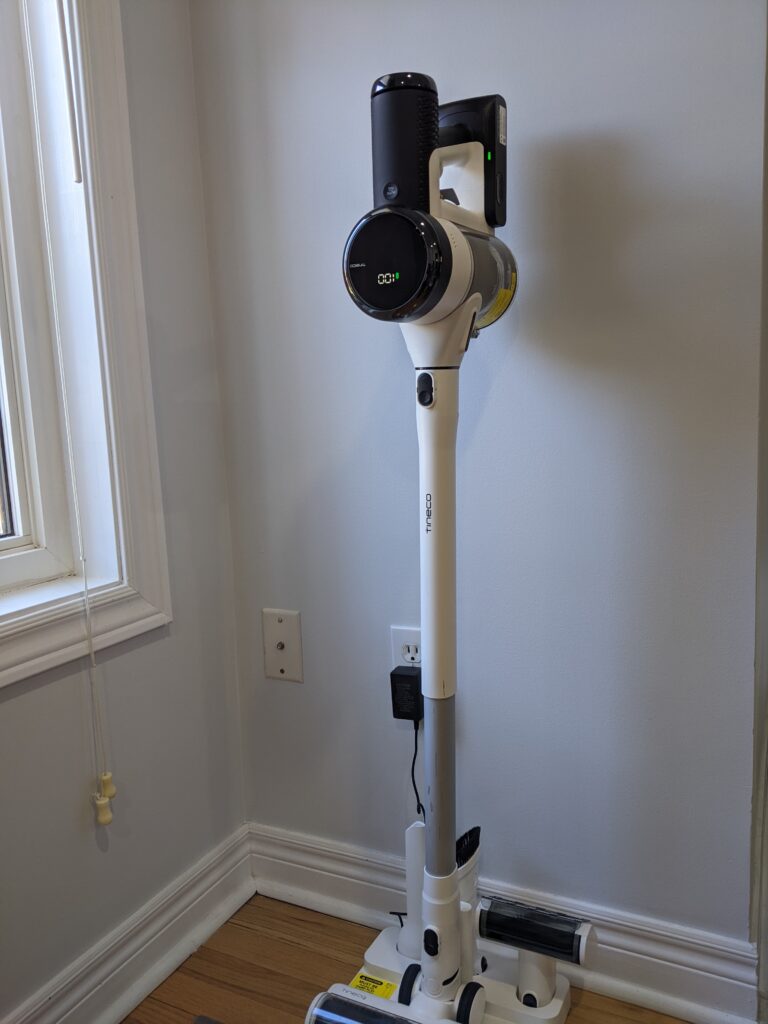 Tineco Pure One S15 cordless vacuum.  Image shows the vacuum in the charging bay.
