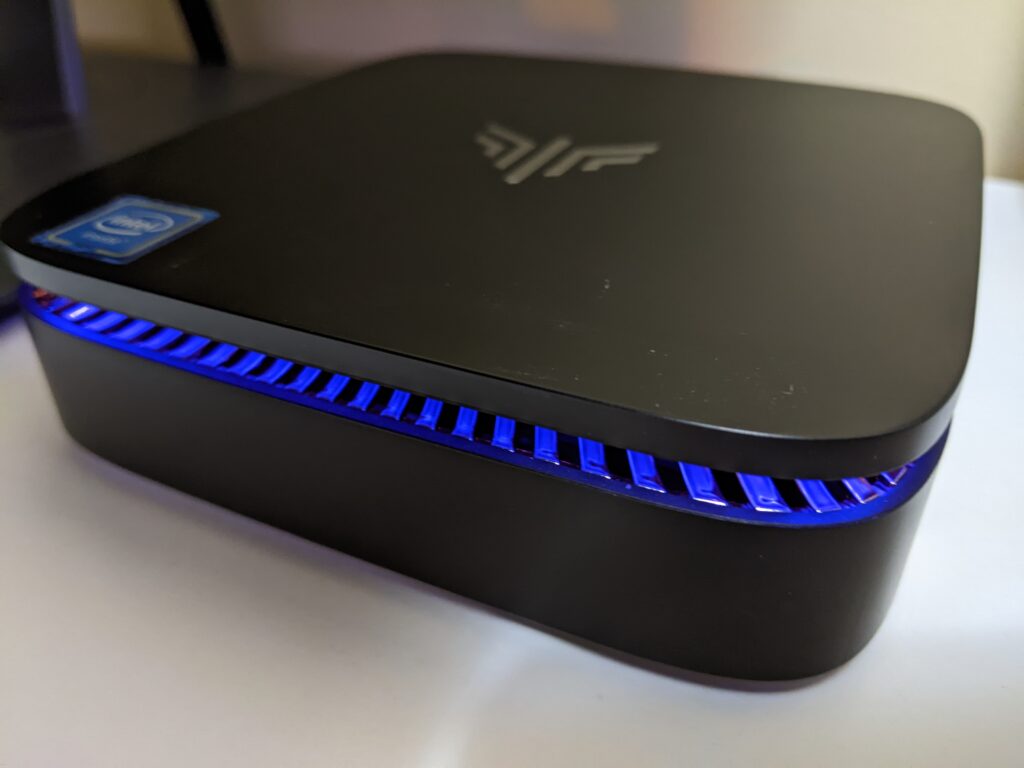 Image of the Kamrui AK1 Pro Mini PC with emphasis on the RGB blue lighting when the unit is powered on.