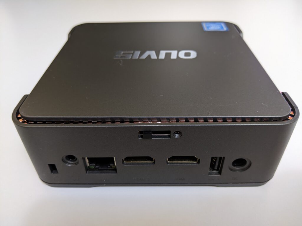 Image of the rear of the OUVISTILE mini pc.  Ports include Kensington lock , power port, Gigabit ethernet, 2x HDMI ports, 1x USB 2.0 port and mic and headphone jack